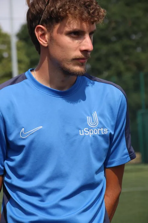 A uSports coach in kit on the pitch