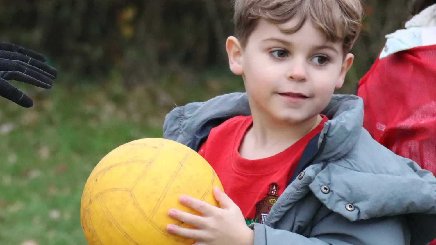 A child holding a ball at a uSports active lunch club