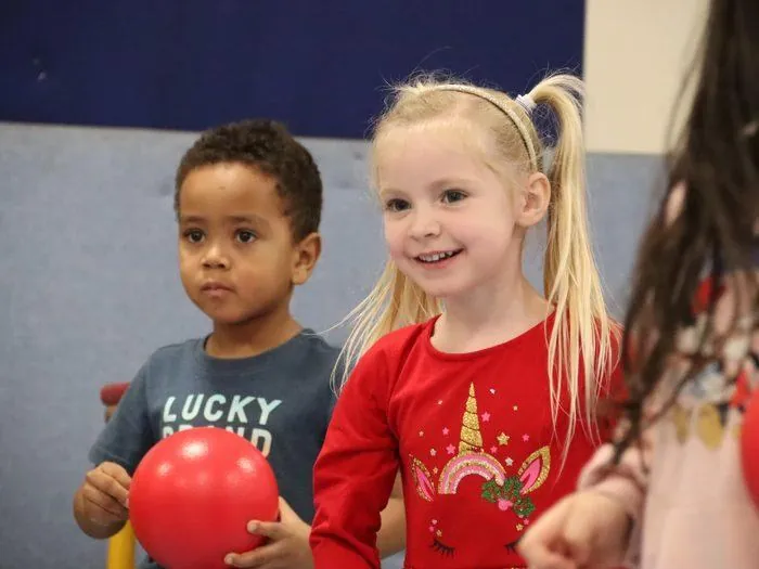 Children holding red balls at a uSports session