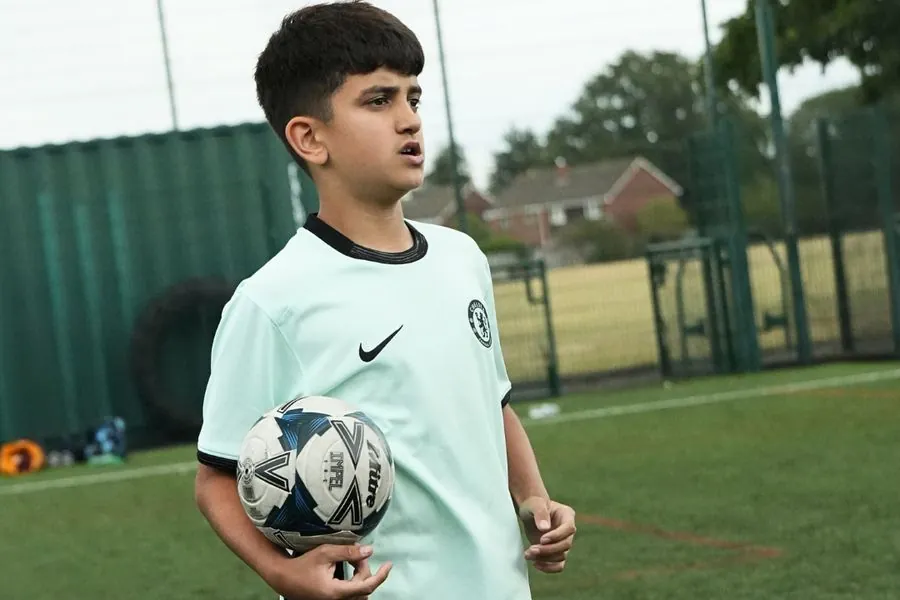 Young footballer holding a ball at a uSports football development centre