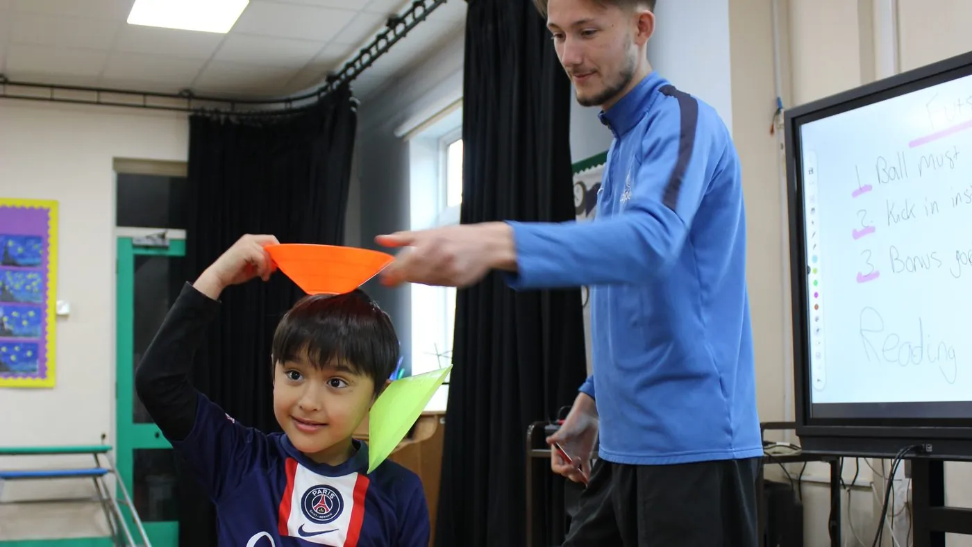 A uSports coach working with a child during an indoor session
