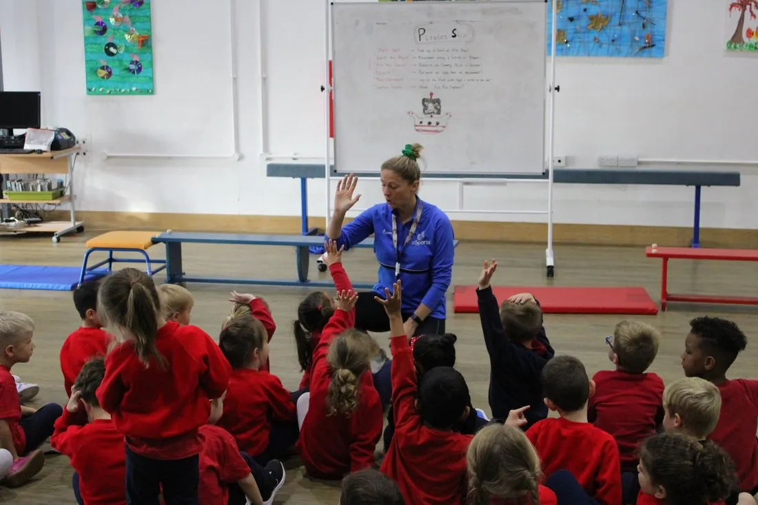 uSports coach delivering a PE lesson to a class of school children