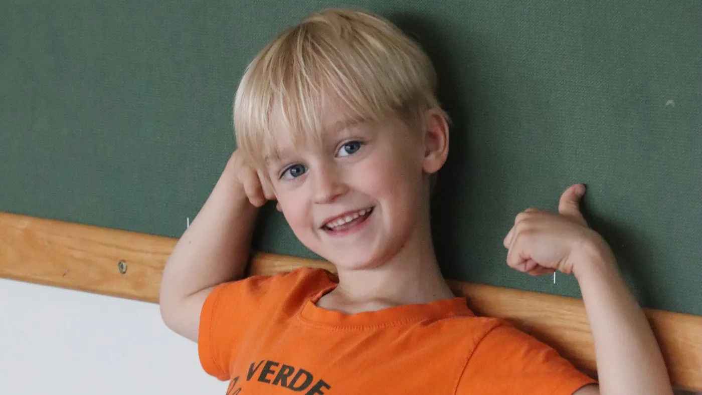 A child smiling and flexing after a uSports session