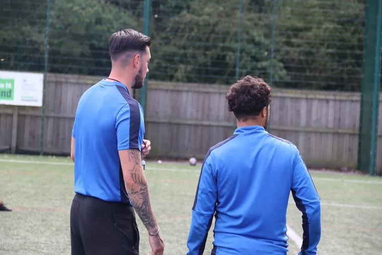Two uSports coaches talking pitchside